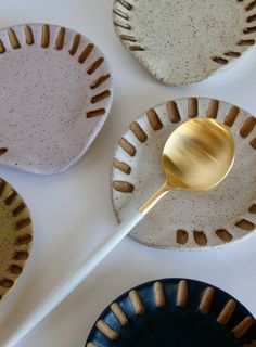 three plates with gold spoons on them