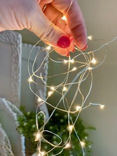 a person is holding some string lights in their hand and it's on the table