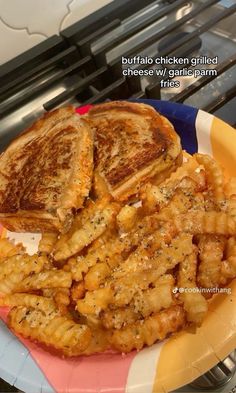 a plate with some food on it sitting next to an open flame oven and the words buffalo chicken grilled cheese over garlic bread fries