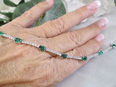 "Trust me when I say you've been wanting one of these outstanding \"diamond\" bracelets. This looks so realonly you will know it's not. This beautiful bracelet is solid sterling silver with tons of sparkling cubic zirconia with beautiful rich green emeralds. Phenomenal design and craftmanship. It measures 7 1/4\" long, and is 3/16\" at its widest. A well made double safety clasp for security. Stamped 925. A true beauty....you will enjoy this for years to come! Non tarnish. New. We also have this amazing bracelet in Aquamarine, Tanzanite, and Blue Sapphire." Emerald Tennis Bracelet, Jewellery Wishlist, Bracelet Emerald, Bracelet Tennis, Emerald Bracelet, Lab Created Emerald, Green Stones, Sterling Bracelets, Palm Beach Fl