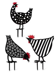 three black and white roosters standing next to each other on top of metal legs