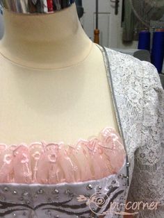 a mannequin wearing a pink and grey dress with beading on it's chest