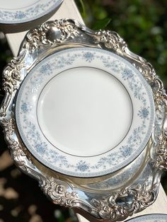 two silver and white plates sitting on top of each other