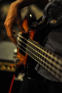 a close up of a person playing an electric guitar with his hand on the strings