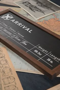 a wooden framed sign sitting on top of a table filled with paper and other items