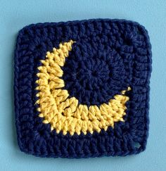 a crocheted square with a crescent in the center on a blue background,