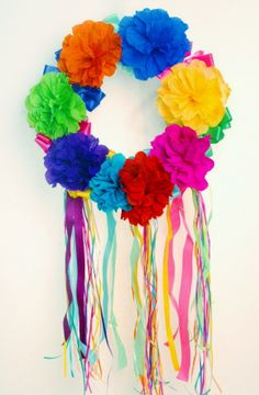 a multicolored paper flower wreath hanging on a wall