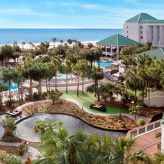 an aerial view of the resort and pool area with palm trees in the foreground