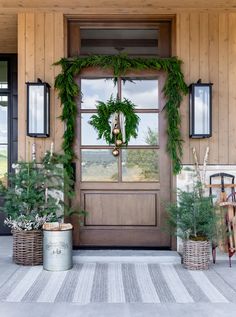 the front door is decorated with greenery and wreaths