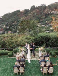 a bride and groom standing at the end of their wedding ceremony on top of a hill