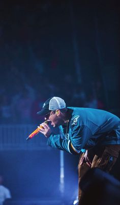 a man holding a carrot in his right hand while standing next to another person on stage