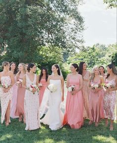 a group of women standing next to each other on top of a lush green field