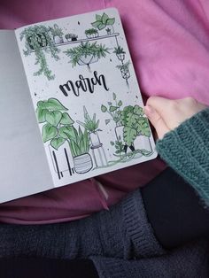 a person holding a notebook with plants on it