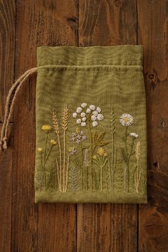 a green bag with white flowers on it