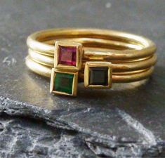 Three 18ct yellow gold rings that stack very neatly together. They are all made in hallmarked 18ct yellow gold and are set with a ruby, emerald and sapphire. Each stone is 3mm square and each band 1.5mm round . They can be made to your size in 1-2 weeks, just leave your details at the checkout. This is a special offer price for all three rings.I can ship these rings by Fed-ex if required at a charge of $30. Otherwise FREE SHIPPINGRuby is  the July birthstone, Sapphire is September and Emerald is Stackable Gold Emerald Cut Rings, Gold Emerald Ring Stackable Fine Jewelry, Gold Stackable Birthstone Ring With Emerald Cut, Gold Emerald Cut Stackable Birthstone Ring, Gold Three Stone Stackable Rings As Gift, Fine Jewelry Gold Stackable Three Stone Rings, Gold Stackable Emerald Ring For Anniversary, Gold Three Stone Ring For May Birthstone, Classic Gold Stackable Ruby Ring