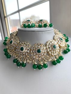 A elegant silver and green choker necklace which comes with earrings and tikka.  This is a Kundan inspired piece and can be worn as a choker or to sit on neckline.  Please note that due to hygiene reasons we are not able to offer any refunds or exchanges. Green Tikka For Party And Diwali Festival, Green Chandbali Jewelry Sets For Party, Green Round Bridal Necklace With Tilla, Round Green Bridal Necklace With Tilla, Festive Green Choker For Wedding, Green Wedding Choker For Festive Occasions, Green Chandbali Necklaces For Party, Green Tikka For Party And Festivals, Heavy Green Tikka For Celebration