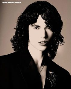 a black and white photo of a man with curly hair