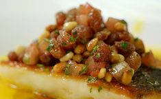 a piece of fish covered in sauce and garnished with parsley on top