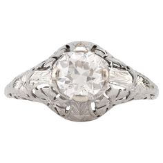 an antique style diamond ring with filigrees on the sides and center stone