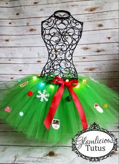 a green tutu with red bows and snowflakes on the bottom, surrounded by christmas decorations