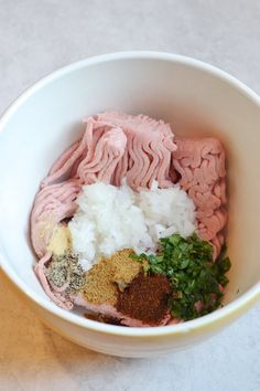 a white bowl filled with meat and spices