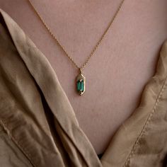 With its modern, understated style, wear this emerald set Amulet necklace for a hint of sparkle and casual luxe. Hanging from the center of the 14K yellow gold chain is a hexagon shaped pendant with two claw prongs that hug a mesmerizing green baguette cut emerald. The best part about this pendent is that it is 100% cu Minimalist Emerald Necklace In Yellow Gold, 14k Gold Octagon Gemstone Necklace, 14k Gold Emerald Cut Birthstone Necklaces, Dainty Emerald Cut Yellow Gold Necklace, Emerald Cut Birthstone Necklace In 14k Gold, 14k Gold Emerald Cut Birthstone Necklace, Minimalist Emerald Pendant Necklace As Birthstone, Minimalist Emerald Pendant Necklace With Birthstone, Yellow Gold Necklace With Emerald Rectangular Pendant