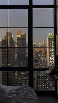 a bedroom with a view of the city at night