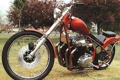 a red motorcycle parked on top of a grass covered field