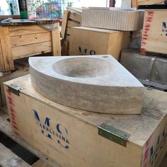 a large stone sink sitting on top of a wooden box in a room filled with boxes