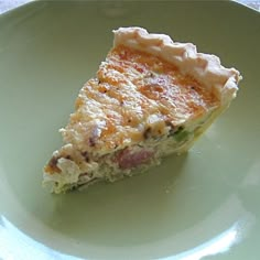 a slice of quiche on a green plate