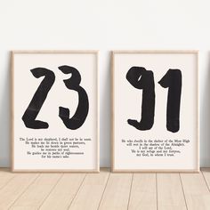 two black and white prints with the numbers twenty and thirteen on them, against a white wall