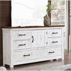 a white dresser sitting in front of a window