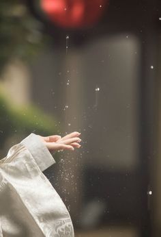 a person's hand reaching for something out of a bag with water droplets on it