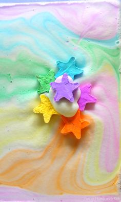 five star shaped candies on top of a rainbow colored cake