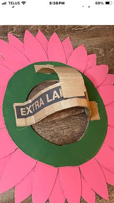 a pink flower with a green circle around it that says extra la on the side