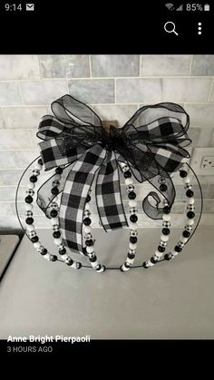 a black and white wreath hanging from the side of a kitchen counter with beads on it