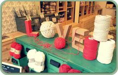 balls of yarn sit on top of a green table