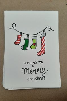 a christmas card with stockings hanging from a line and the words wishing you merry christmas