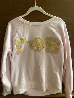 a pink sweatshirt with the number 75 printed on it