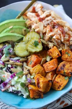 a blue plate topped with salad and tofu