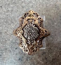 Beautiful Vintage 10K Yellow Gold Diamond Shield Ring This lovely ring is made of 10K Yellow Gold.  There are 7 tiny Diamonds in the middle. The ring is size 6.25 and the weight is 2.5 grams.  It is marked 10K inside the band. Excellent condition.  Will ship in a gift box. Stock # R1533 14k Gold Filigree Ring Stamped 14k For Promise, Ornate 14k Gold Promise Ring, Antique Gold Flower Ring For Anniversary, Antique Cluster Ring With Diamond Cut For Promise, Ornate 14k Gold Ring Stamped 14k, Gold Filigree Ring With Diamond Accents In 14k Gold, Antique Gold Cluster Ring For Promise, Ornate Gold Rings With Diamond Cut, Ornate Gold Diamond Ring For Anniversary