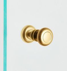 a close up of a door knob on a white and blue wall with green trim