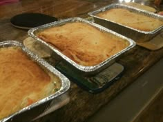 three pans filled with food sitting on top of a counter next to each other