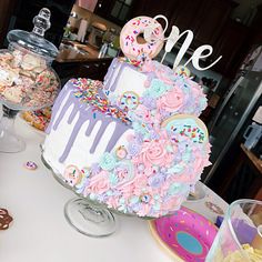 there is a birthday cake with donuts and sprinkles on the table