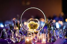 a table topped with lots of glass vases filled with flowers