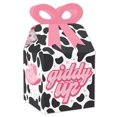 a black and white cow print box with pink ribbon on top, it says giddy up