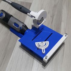 a blue and white device on top of a wooden floor next to a tool holder