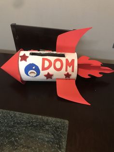 a paper rocket with the word dom written on it and red, white and blue stars