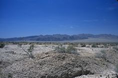 an arid landscape with mountains in the distance