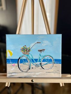 a painting of a blue bicycle on the beach